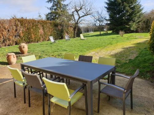 a table and chairs with a field in the background at Gite les champs Darié 3 étoiles in Island