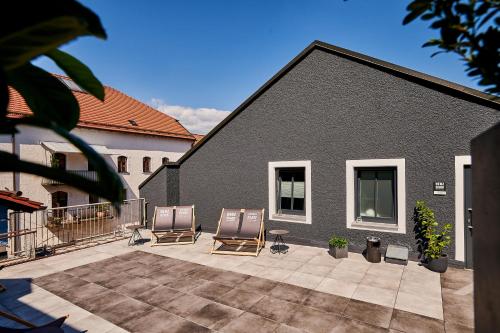 two chairs sitting on a patio in front of a building at Hotel & Restaurant Herzstück Waldkirchen in Waldkirchen