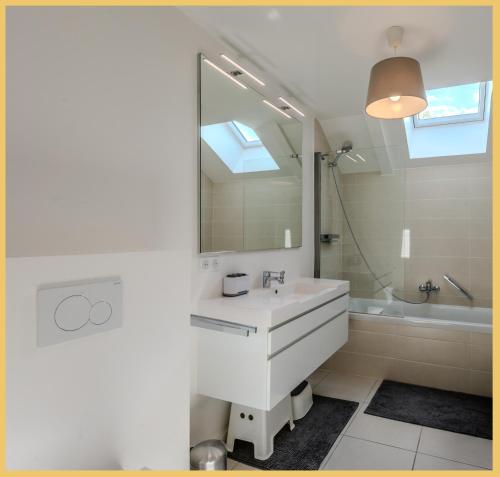 une salle de bain avec un lavabo, un miroir et une baignoire dans l'établissement Villa Soléa I Veigy-Foncenex, à Veigy-Foncenex