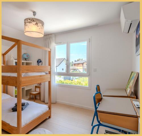 - une chambre avec des lits superposés, un bureau et une fenêtre dans l'établissement Villa Soléa I Veigy-Foncenex, à Veigy-Foncenex