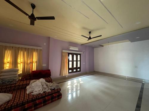 a living room with a ceiling fan and a couch at SK Luxury Homestay in Sivasagar