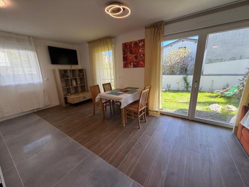 une salle à manger avec une table et des chaises et une fenêtre dans l'établissement Villa ROSA seasonalflat Au RDC 80 rue Paul Vaillant Couturier Malakoff 92240, à Malakoff
