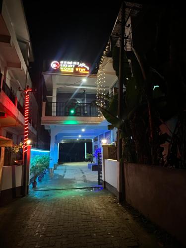 a building with a neon sign at night at SK Luxury Homestay in Sivasagar