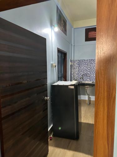 a bathroom with a black door and a sink at SK Luxury Homestay in Sivasagar