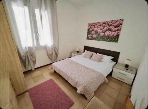a bedroom with a bed and a painting of pink tulips at Cacciatore in Rosolina