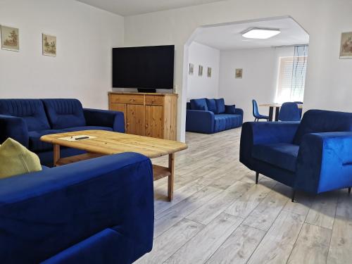 a living room with blue couches and a tv at Hotel Garni Jägerhof in Sigmaringen