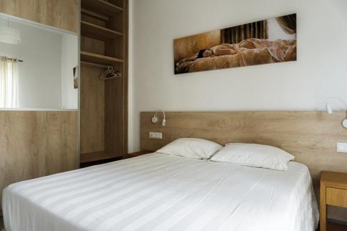 a bedroom with a large bed with white sheets at StelAnna-Apartments in Rethymno Town