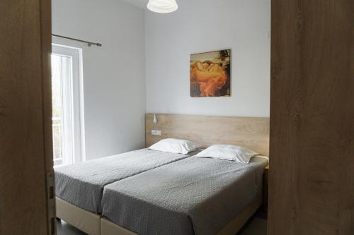 a bed in a bedroom with a picture on the wall at StelAnna-Apartments in Rethymno Town