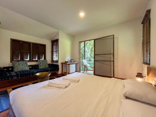 a bedroom with a large white bed in a room at NernJamsai in Sop Poeng