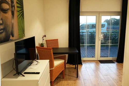 a living room with a desk and a table and a window at Studio mit 1 Schlafzimmer in Oyten