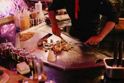 a person is preparing food in a kitchen at Munduk Heaven Luxury Villas in Munduk