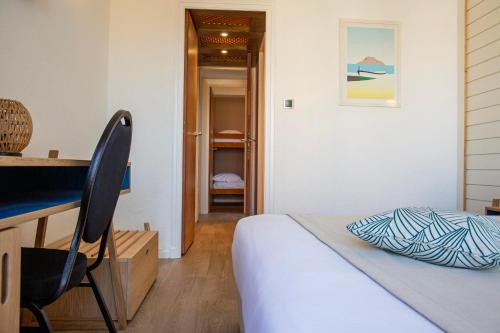 a bedroom with a bed and a desk and a chair at Grand Hôtel Du Lido in Argelès-sur-Mer