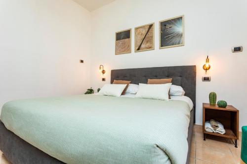 a bedroom with a large bed with white walls at Civico 1 Apt - Acireale in Acireale