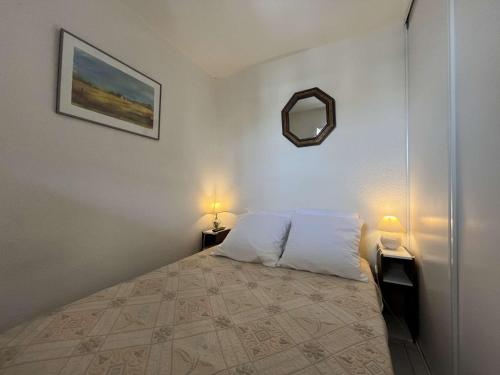 - une chambre avec un lit, deux lampes et un miroir dans l'établissement Appartement Studio Cabine - Gruissan GN160-331, à Gruissan