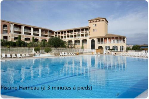 une grande piscine devant un immeuble dans l'établissement Le rêve d'azur, à Saint-Raphaël