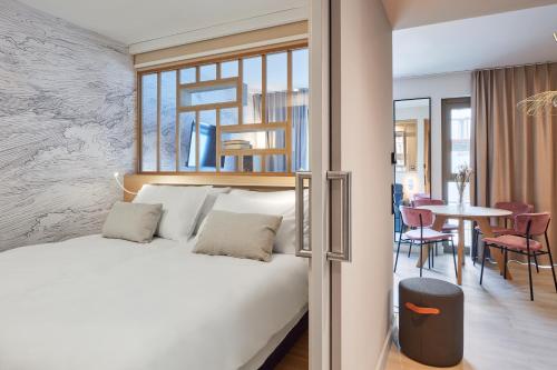 a bedroom with a bed and a dining room at Aparthotel Adagio Stuttgart NeckarPark in Stuttgart