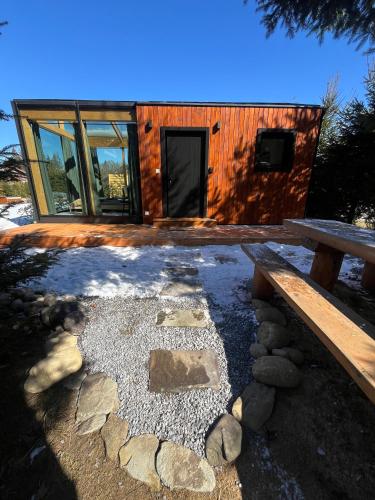 a log cabin with a bench and a table at Domček pri studenom potoku in Nižná