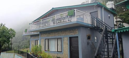a house with a balcony on top of it at Birds Hill View Homestay in Nainital