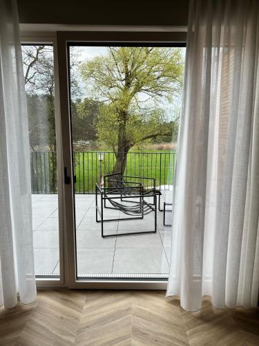 a sliding glass door with a table on a patio at Hotel Pflugsmühle in Abenberg