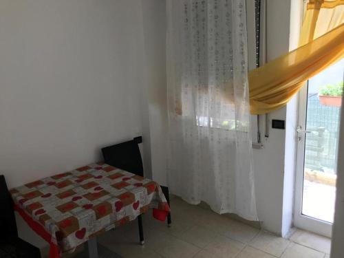 une chambre avec une table et une fenêtre avec un rideau dans l'établissement Villa Grazia, à Rimini