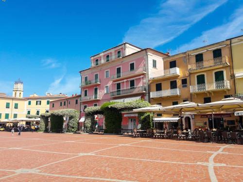 a group of buildings with tables and chairs and umbrellas at Casa Romita 9 - ArgonautiVacanze in Porto Azzurro