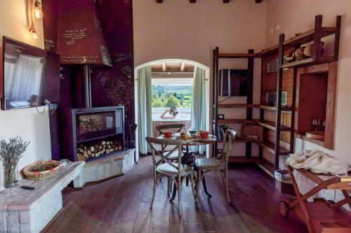 Una cocina con una mesa y una chimenea y una ventana. en Villa & Spasuitebo Roma, en Mazzano Romano