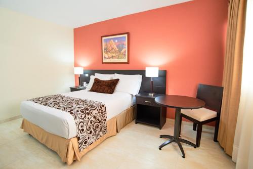 a hotel room with a bed and a table at Hotel Arizona Suites Cúcuta in Cúcuta