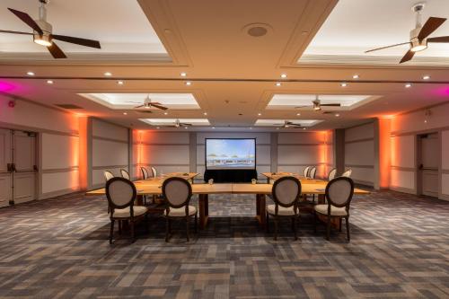 a conference room with a table and chairs and a projection screen at Royal Lahaina Resort & Bungalows in Lahaina