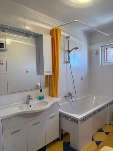 a bathroom with a sink and a bath tub at Holiday Home Panorama in Zubovići