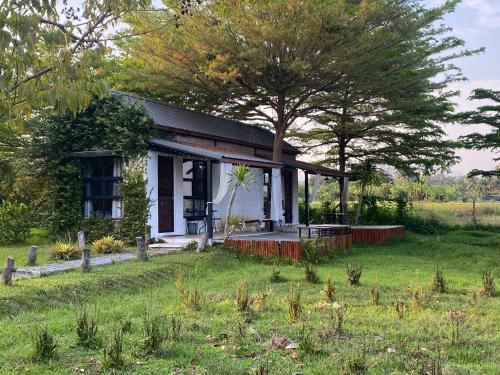 a small house in the middle of a field at At HuG in Ban Muang Chum