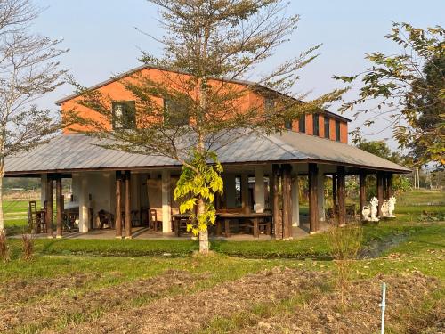 a house with a tree in front of it at At HuG in Ban Muang Chum