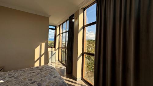 a bedroom with a bed and a large window at Datuna in K'obulet'i