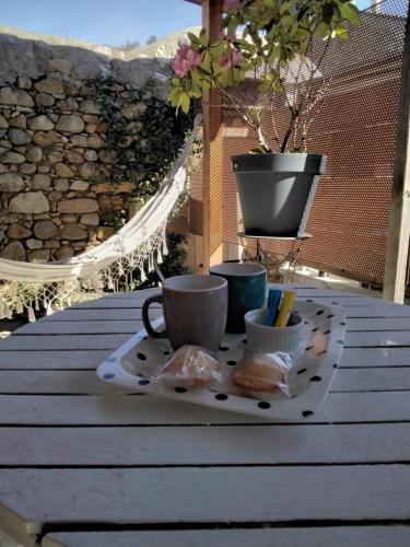 a table with two cups on a tray on a balcony at Chambre terrasse et parking privés 400 m du marché VALLON in Vallon-Pont-dʼArc