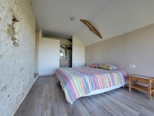 une chambre avec un lit et une table en bois dans l'établissement Maison à louer, à Beaumont-Pied-de-Boeuf