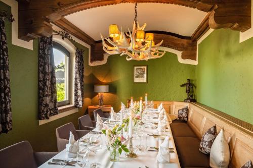 a long table in a room with green walls and a chandelier at Eurener Hof in Trier