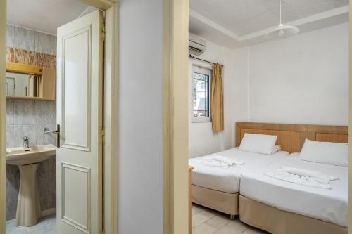 a bedroom with a bed and a sink in a room at Evi Studios & Apartments Pefkos in Pefki Rhodes