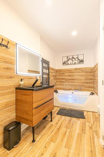 La salle de bains est pourvue d'une baignoire, d'un bureau et d'un lavabo. dans l'établissement Appartement proche La norma Aussois, à Villarodin-Bourget