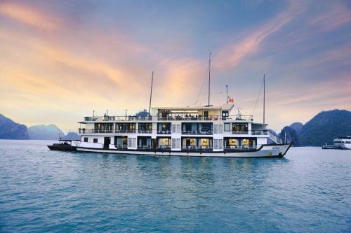 a ferry boat on the water at sunset at Mila Cruises in Ha Long