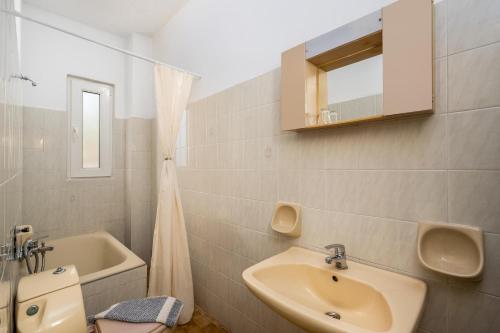 a bathroom with a sink and a toilet and a mirror at Evi Studios & Apartments Pefkos in Pefki Rhodes