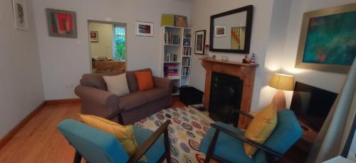 een woonkamer met een bank en een stoel bij No 14 -A Cosy Townhouse in Westport in Westport