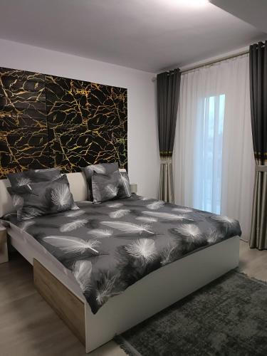 a bedroom with a bed with a black and white comforter at GH Apartments 1 in Gura Humorului