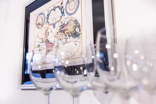 a row of wine glasses in front of a picture at Planetarium - Stare Miasto, Parking Free in Toruń