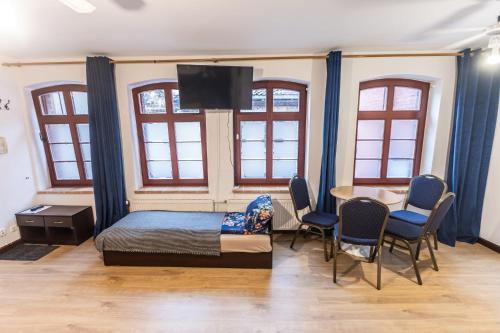 a bedroom with a bed and a table and chairs at Planetarium - Stare Miasto, Parking Free in Toruń