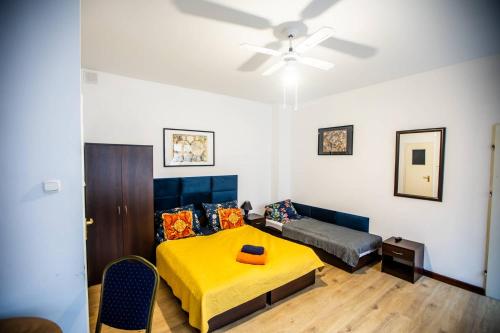 a bedroom with a yellow bed and a couch at Planetarium - Stare Miasto, Parking Free in Toruń