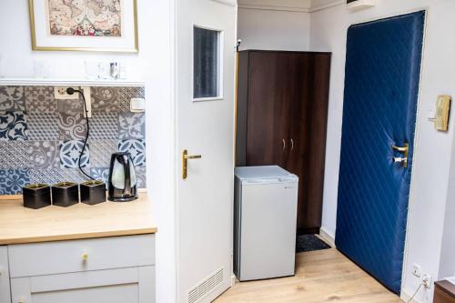 a small kitchen with a blue door and a counter at Planetarium - Stare Miasto, Parking Free in Toruń