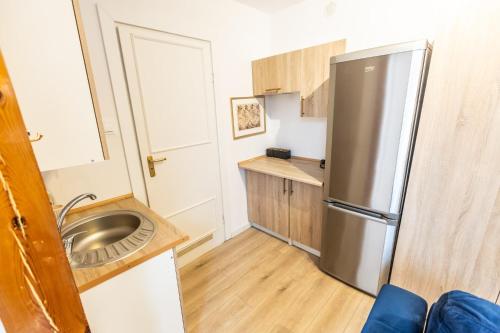 a small kitchen with a stainless steel refrigerator at Planetarium - Stare Miasto, Parking Free in Toruń