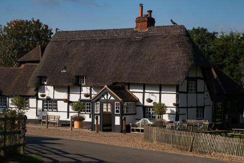 a black and white building with a thatched roof at The Bottle & Glass Inn - Book All 3 Rooms in Henley on Thames