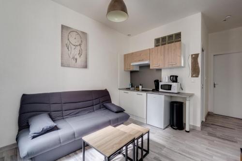 un salon avec un canapé et une cuisine dans l'établissement L'Escale Matabiau Hypercentre, à Toulouse