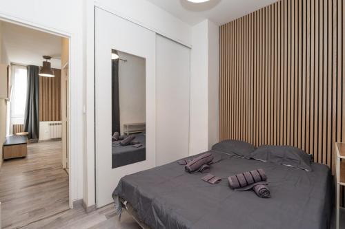 une chambre avec un lit avec deux pantoufles dessus dans l'établissement L'Escale Matabiau Hypercentre, à Toulouse