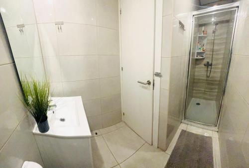 a white bathroom with a shower and a sink at Central Lisbon rooms, ideal location for tourists in Lisbon